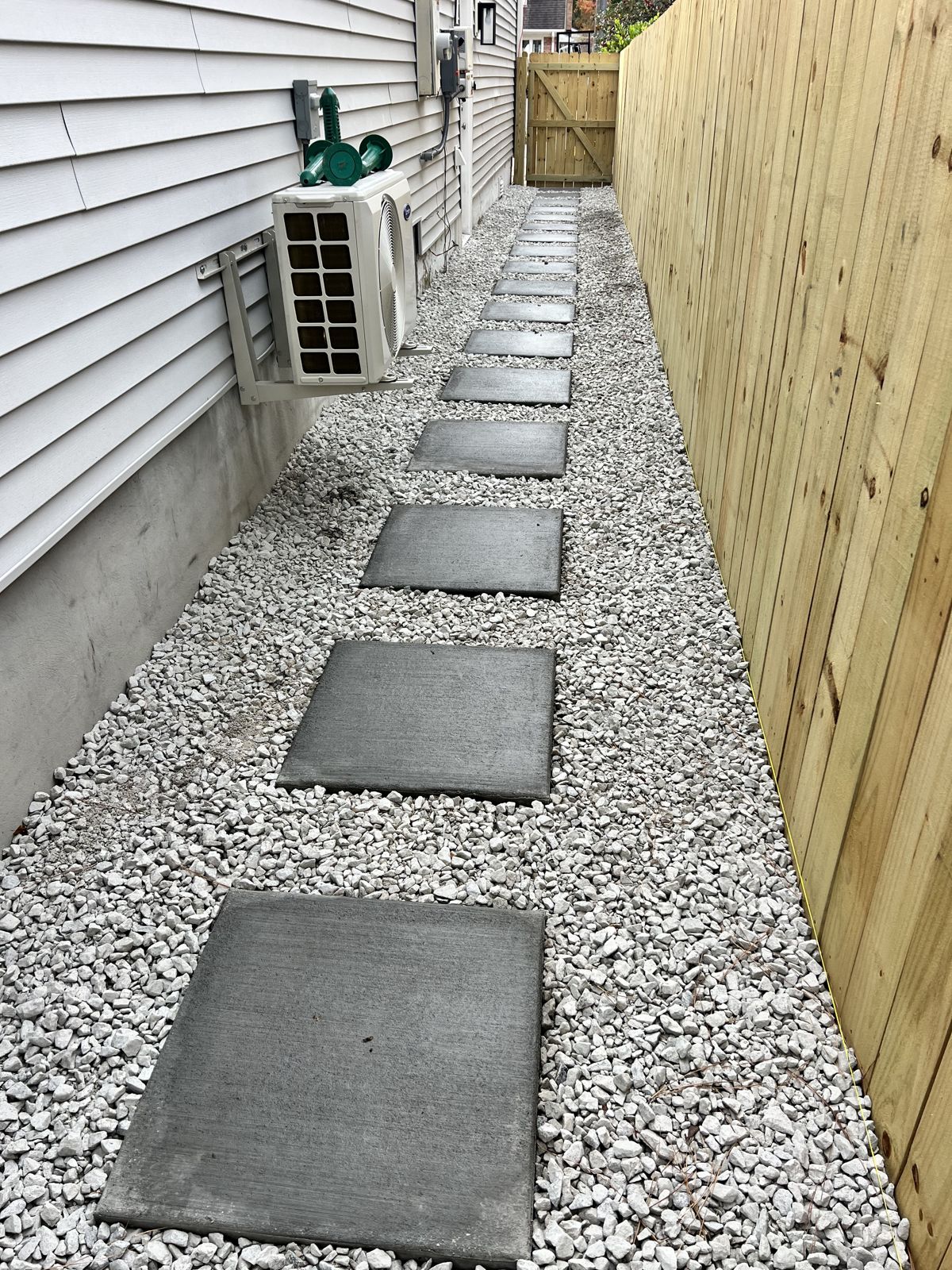 Paver stepping-stone walkway set in gravel along a side yard