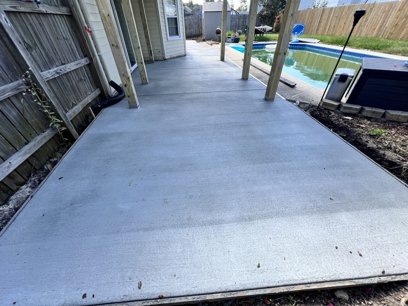 Broom-finished concrete pool deck poured under a covered patio