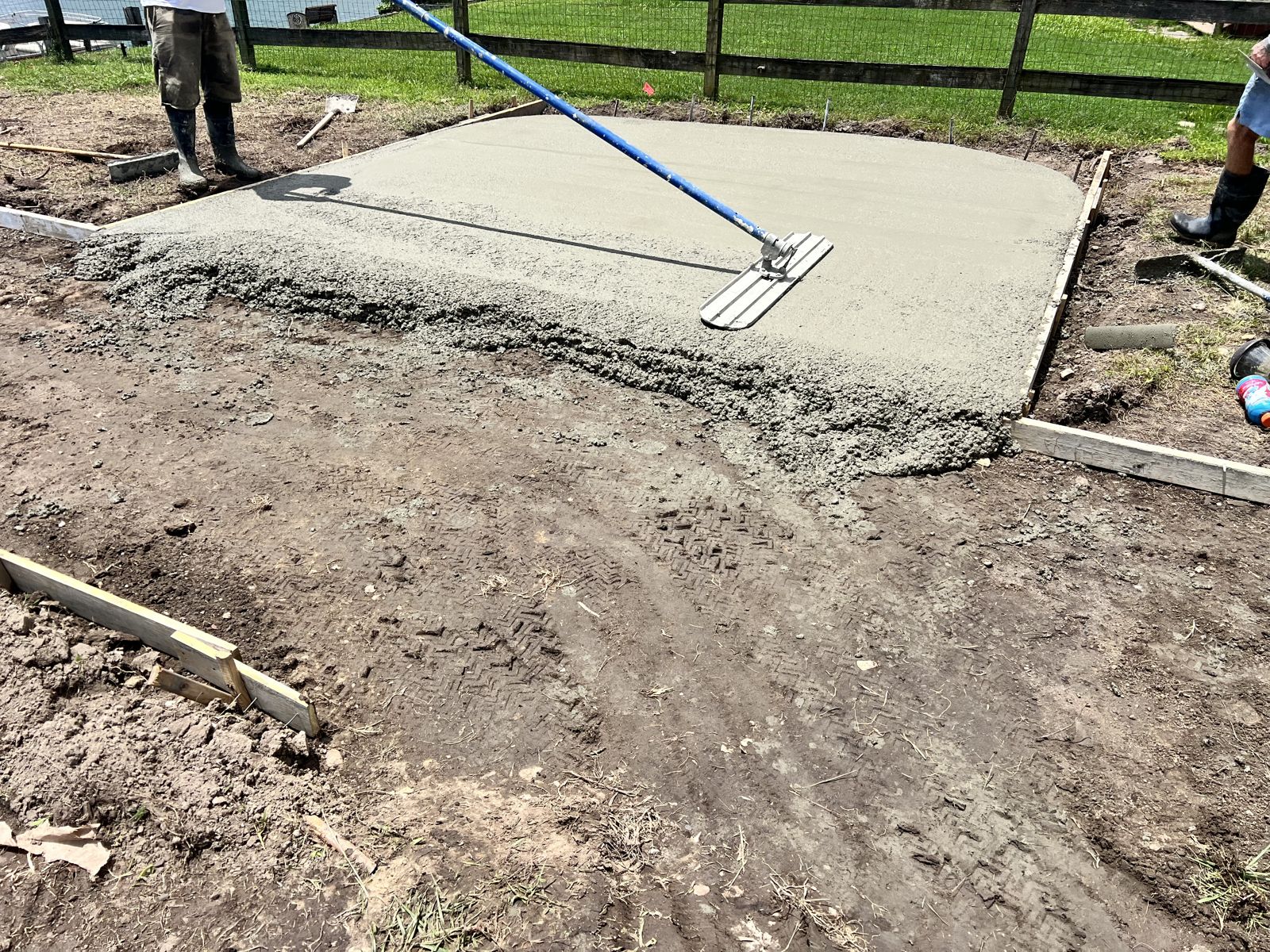 Crew bull-floating a freshly poured concrete slab