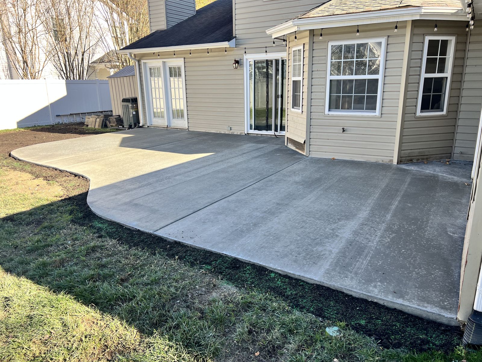 Large wraparound concrete patio across the back of a home